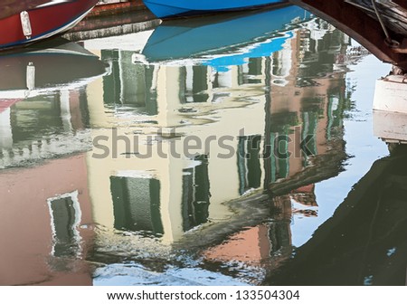 The reflection in the water channel of the colored houses - Burano, Venice, Italy