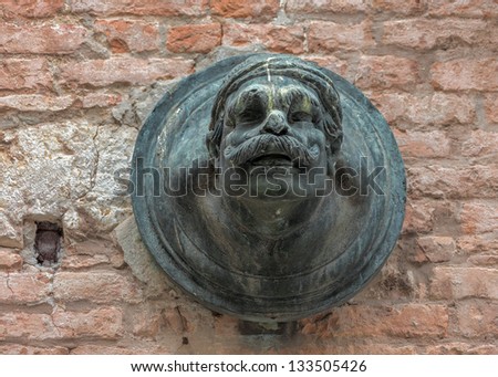 Ancient sculpture of a man\'s head on the wall of a Venetian home - Venice, Italy