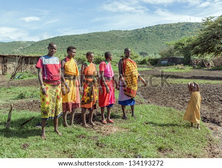 MASAI MARA, KENYA - DECEMBER 2: Masai warriors dancing traditional jumps as cultural ceremony. As well as women sing and dance. Masai Mara National Park, December 2, 2011 in Kenya