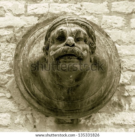 Ancient sculpture of a man\'s head on the wall of a Venetian home - Venice, Italy (stylized retro)