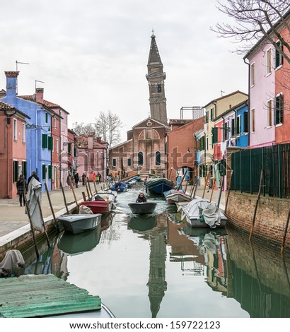 The Leaning Bell Tower reflected in water canal on the island of Burano - Venice, Italy