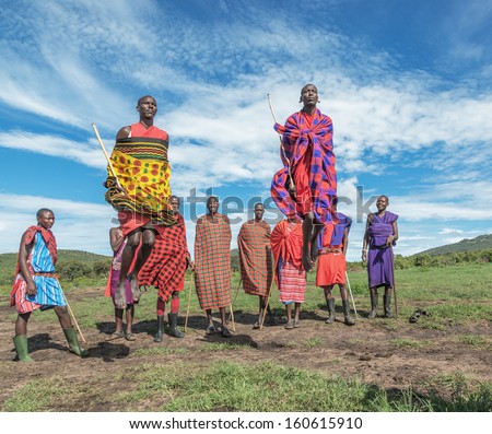 Masai Mara, Kenya - December 2: Masai Warriors Dancing Traditional Jumps As Cultural Ceremony. As Well As Their Women Sing And Dance. Masai Mara National Park, December 2, 2011 In Kenya