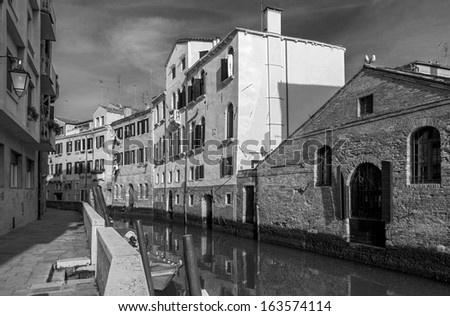 Narrow venetian canal in the morning light - Venice, Italy (black and white)