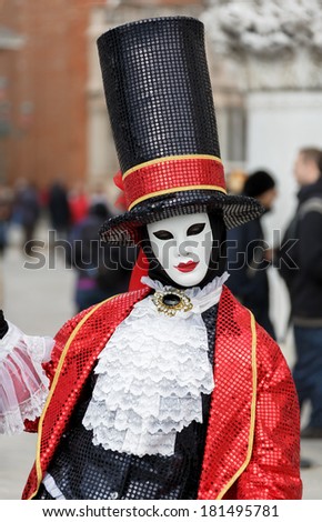 Unrecognizable persons wearing carnival costume (mask) in Saint Mark square in Venice, Italy. In 2014 the Carnevale di Venezia was held between 15 Feb - 04 Mar