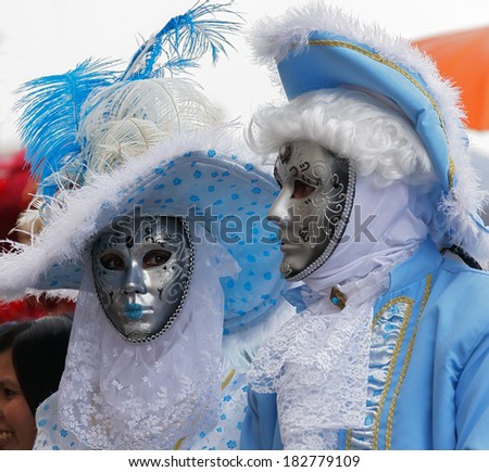 VENICE, ITALY - MAR 04, 2014: Unrecognizable persons wearing carnival costume (mask) in Saint Mark square in Venice, Italy. In 2014 the Carnevale di Venezia was held between 15 Feb - 04 Mar