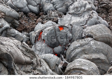 Molten lava flows on the surface of the cracks in the previously cooled lava - volcano Tolbachik, Kamchatka, Russia