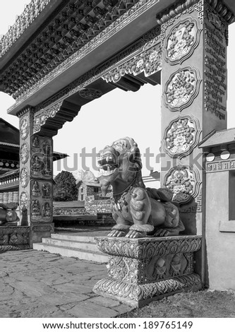 TENGBOCHE, NEPAL - OCTOBER 30, 2012: One of the two mythical beasts (right) guarding the gate of the Tengboche monastery, Himalayas (black and white)