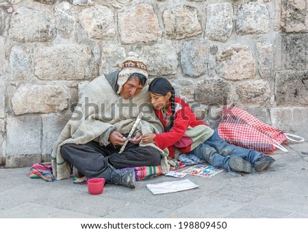 CUSCO, PERU - JANUARY 02, 2014: An old Indian man and a young girl sitting near the walls of the Cathedral of Cusco in Sacred valley of the Incas of Peru