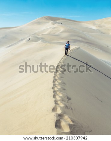 Tourists on the slope of the Dune 7 in Sossusvlei plato of Namib Naukluft National Park - Namibia, South-West Africa
