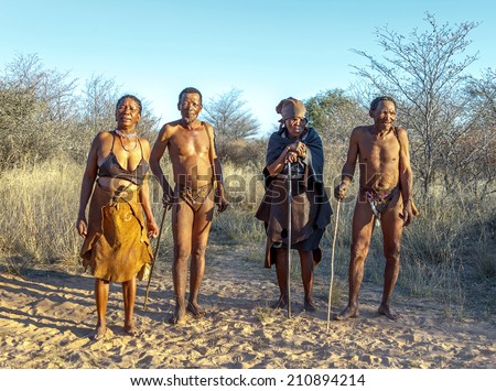 BUITEROS, NAMIBIA - JULY 17, 2014: Hunters Bushmen and their wives posing tourists. The San people, also known as Bushmen are members of various indigenous hunter-gatherer peoples of Southern Africa.