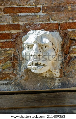 Ancient sculpture of a man\'s head on the wall of a Venetian home - Venice, Italy