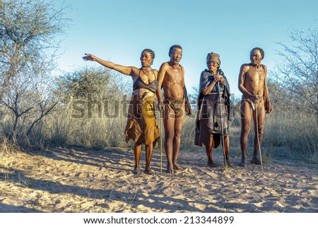 BUITEROS, NAMIBIA - JULY 17, 2014: Hunters Bushmen and their wives posing tourists. The San people, also known as Bushmen are members of various indigenous hunter-gatherer peoples of Southern Africa.