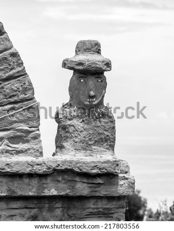 Traditional sculpture standing on a Rocky Arch on Taquile Island - Titicaca lake, Peru (black and white)