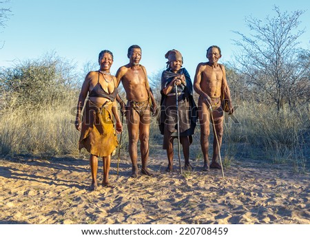BUITEROS, NAMIBIA - JULY 17, 2014: Hunters Bushmen and their wives posing tourists. The San people, also known as Bushmen are members of various indigenous hunter-gatherer peoples of Southern Africa