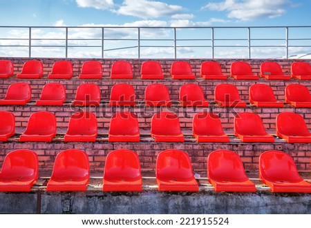Empty red plastic chairs at a football stadium