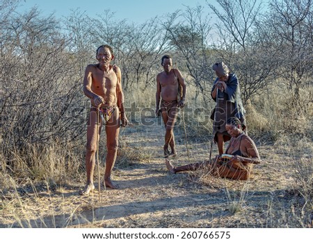 BUITEROS, NAMIBIA - JULY 17, 2014: Hunters Bushmen and their wives posing tourists. The San people, also known as Bushmen are members of various indigenous hunter-gatherer peoples of Southern Africa
