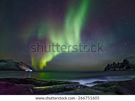 Aurora borealis (Polar lights). View to Steinfjord on Senja island (Oksan on Background)Polar lights) over the mountains. View to Mefjord on Senja island - Lofoten islands, Norway