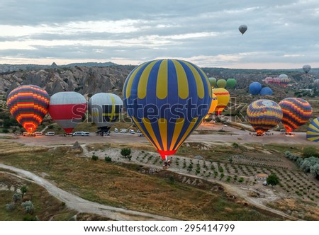 Hot air balloons (atmosphere ballons) flying over mountain landscape at Cappadocia, UNESCO World Heritage Site since 1985) - Turkey