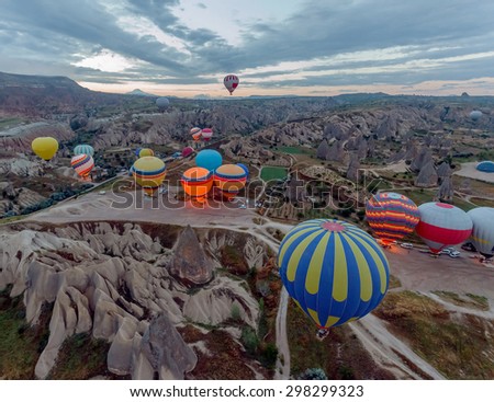 Hot air balloons (atmosphere ballons) flying over mountain landscape at Cappadocia, UNESCO World Heritage Site since 1985) - Turkey