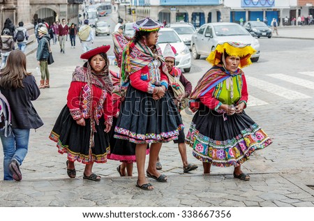 CUSCO, PERU - JANUARY 02, 2014: Family of Peruvian Indians in traditional dress goes on the Central square of Cusco - Peru, Latin America