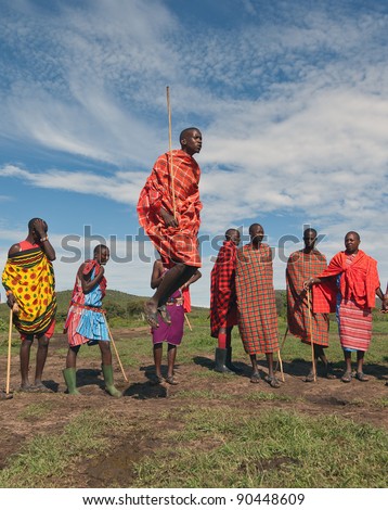 MASAI MARA, KENYA - DECEMBER 2, 2011: Masai warriors dancing traditional jumps as cultural ceremony. As well as women sing and dance. Masai Mara National Park