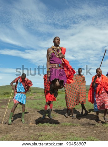MASAI MARA, KENYA - DECEMBER 2: The masai warriors dancing traditional jumps as cultural ceremony. As well as their women sing and dance. Masai Mara National Park, December 2, 2011 in Kenya