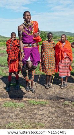 MASAI MARA, KENYA - DECEMBER 2: The masai warriors dancing traditional jumps as cultural ceremony. As well as women sing and dance. Masai Mara National Park, December 2, 2011 in Kenya
