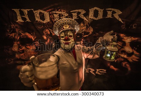 Man dressed as clown terrible captain with a mug of beer in his hand.