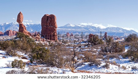 Balanced Rock in Arches National Park, with snow covered La Sal Mountains.