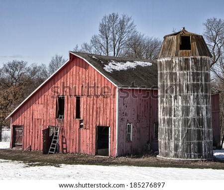 Landscape springtime image of an old farmstead, with weathered barn with wooden silo.  Springtime in Wisconsin