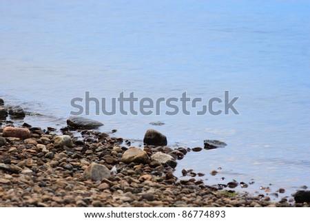 Close Up of Water Lapping Over Pebbles on the Beach