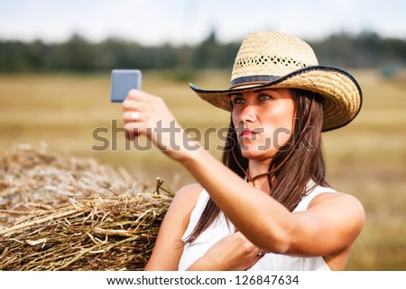 Woman in cowboy hat looking in the mirror.