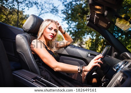 Blond woman in modern cabriolet.
