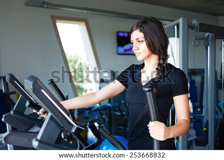 Running brunette in black t-shirt at gym.