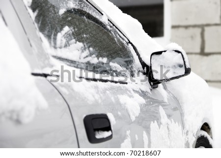 Snow covered silver car.