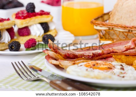 Breakfast, eggs and bacon, Belgian waffles with berries and whipped cream