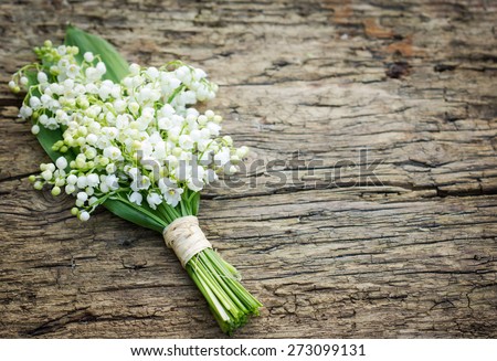 Bouquet of lilies of the valley on the wooden board