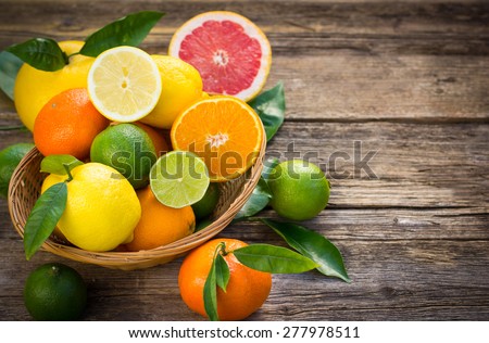 Fresh and juicy citrus fruits in the basket on the rustic table