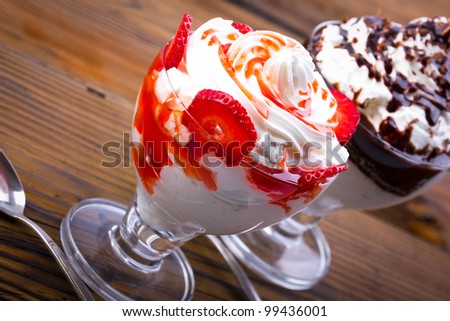 Two portion of whipped cream with strawberries and chocolate