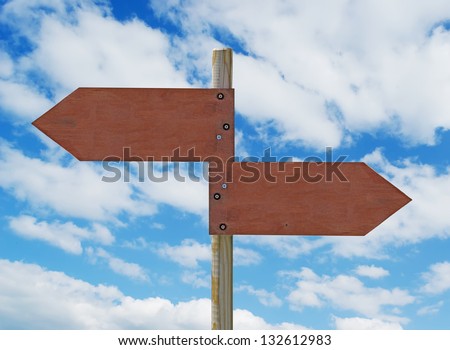 wooden crossroad sign on cloudy background