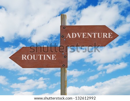 wooden crossroad sign on cloudy background with adventure vs routine  writing