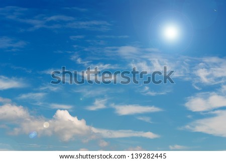 blue sky and white clouds with lens flare