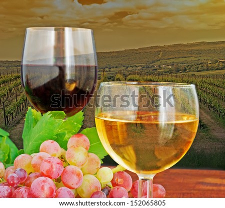 two glasses of wine on a wooden table by a vineyard at dusk