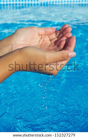 girl hands dropping the water in a pool