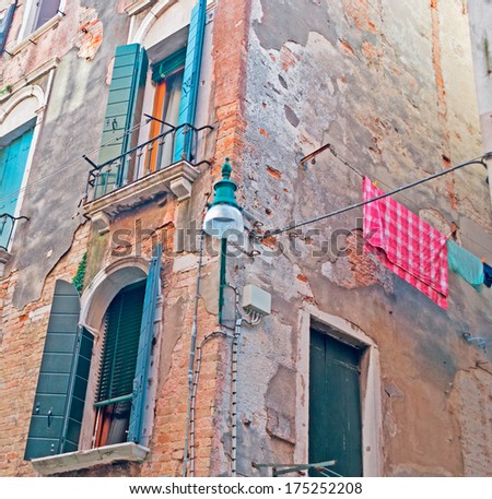 laundry line with clothes and street lamp in an old building in Venice, Italy