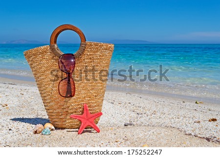 straw bag and sunglasses by the sea