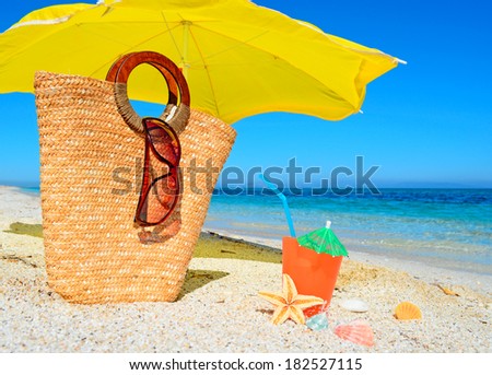 straw bag and drink by the shore