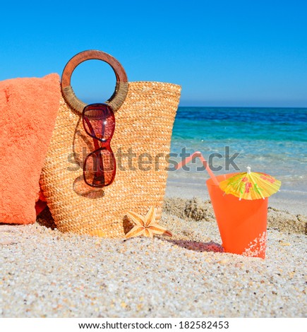 drink and straw bag on the shore