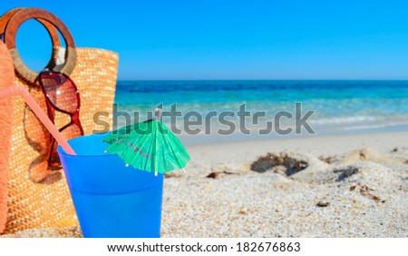 blue drink  and straw bag by the sea