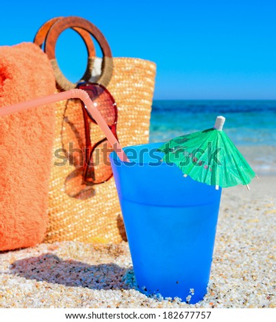 blue drink  and straw bag by the sea